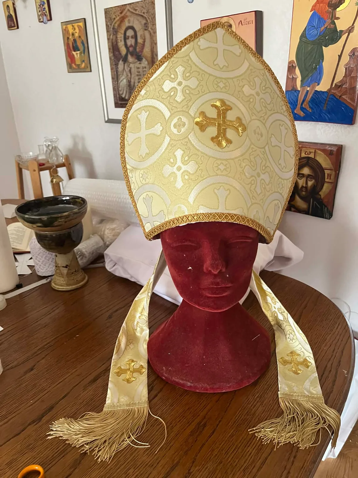 A gold and white embroidered mitre with a gold cross and matching lappets.