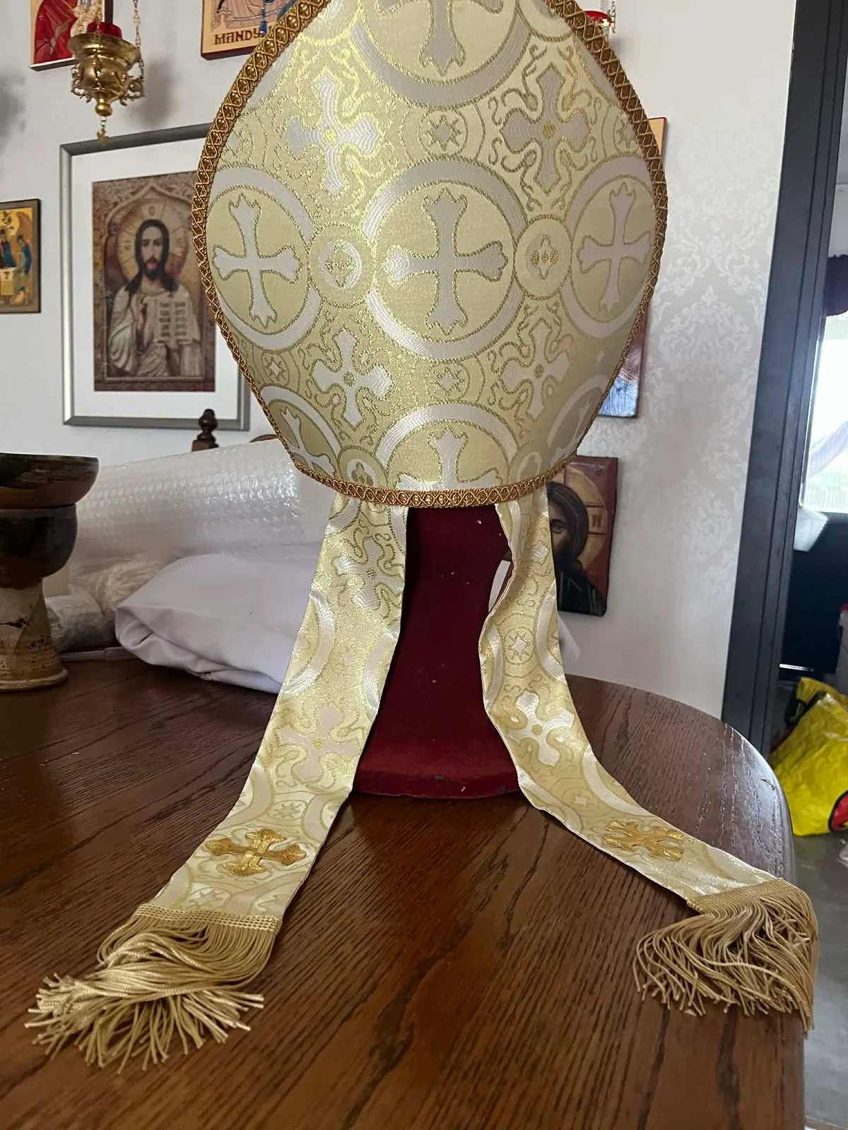 Gold and white patterned fabric, braided trim and fringed lappets on a handmade mitre.